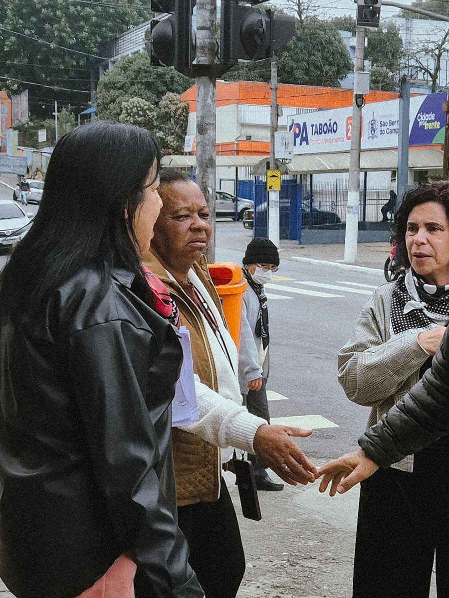 Sandra do Leite conversando com moradoras na calçada, em frente ao Pronto Atendimento do Taboão