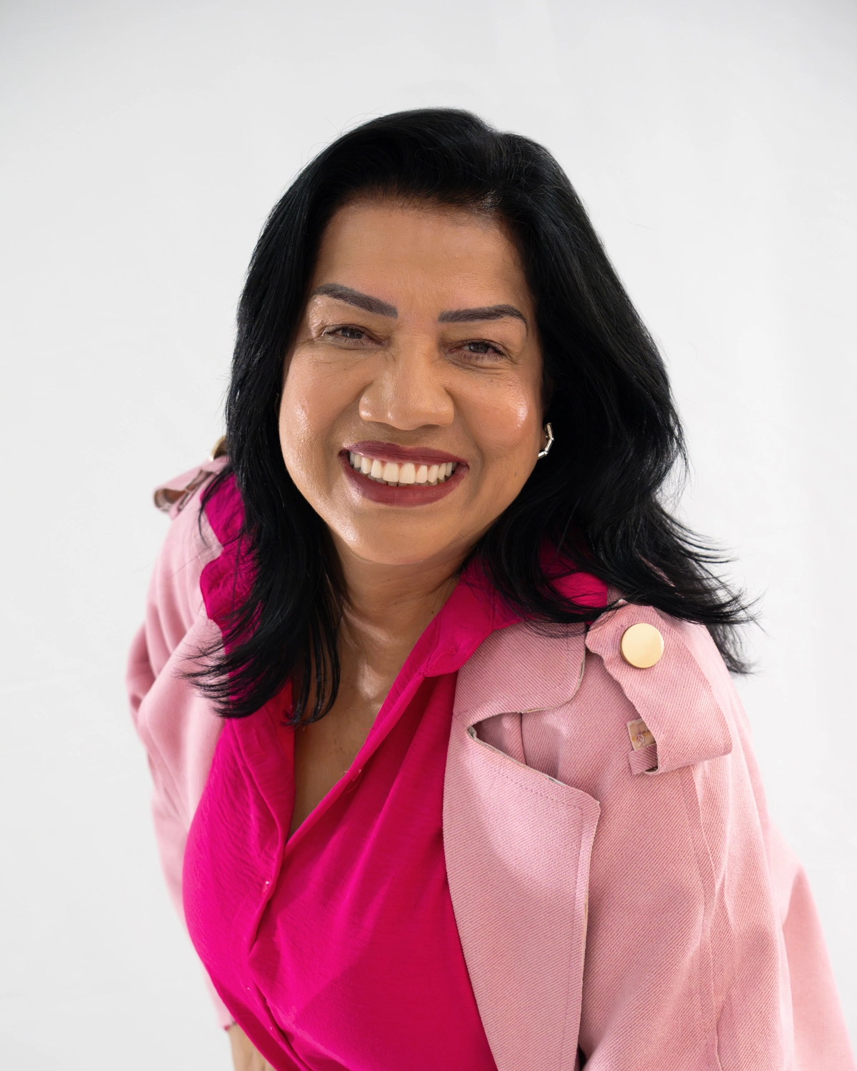 Sandra do Leite sorrindo, de blazer rosa sobre blusa pink